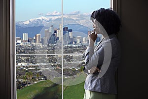 Businesswoman in Los Angeles Looking at Office Window