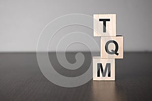 Businesswoman made word tqm with wood building blocks
