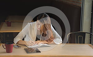 Businesswoman makes a note in notebook.