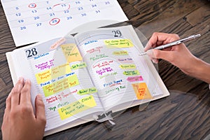 Businesswoman Making Agenda On Diary