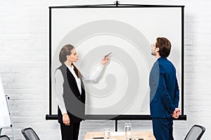 businesswoman making presentation and pointing at blank whiteboard