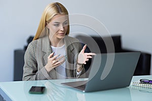 Businesswoman making video call to business partner using laptop. Young woman having discussion with corporate client. Remote job