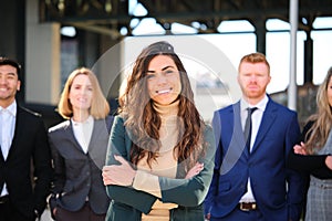 Businesswoman manager CEO and her team smiling and looking at camera.