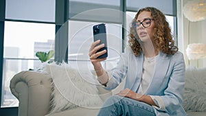 Businesswoman manager wearing suit making call on cellphone showing OK sign hand