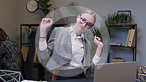 Businesswoman manager working on laptop at desk, dancing, celebrate victory achieved good job result