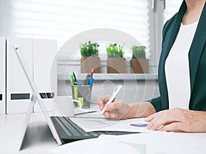 Businesswoman marks document with the marker. Businesswoman or entrepreneur in the home office. Online business, marketing or