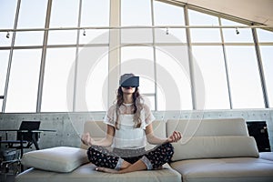 Businesswoman mediating while using virtual reality simulator in office