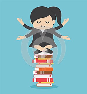 Businesswoman meditate on stack of books