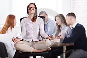 Businesswoman Meditating In Office