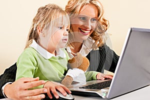 Businesswoman and mother showing kid the internet photo