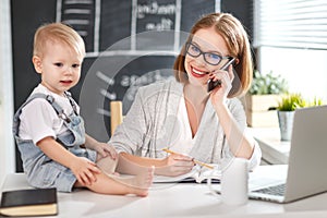 Businesswoman mother woman with toddler working at computer