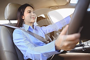 Businesswoman multitasking while driving car working and talking on cell phone on the road.