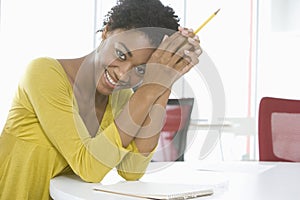 Businesswoman With Notepad And Pencil Sitting At Table