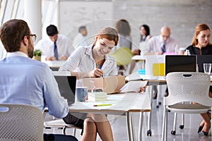 Businesswoman In Office Addressing Package For Shipping photo