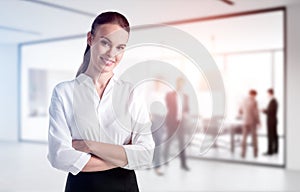 Businesswoman in office interior, blurred background with people