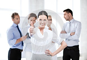 Businesswoman in office showing thumbs up