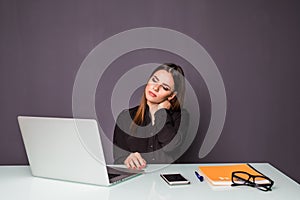 Businesswoman in office working with laptop. Woman sitting at her working desk hands on her neck of pain