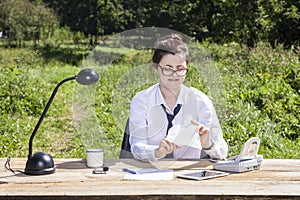 Businesswoman opens an envelope with a gift