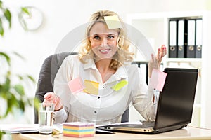 Businesswoman overwhelmed with sticky reminder