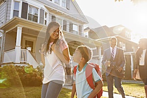 Businesswoman Parents Walking Children To School On Way To Work