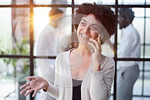 Businesswoman with phone in modern office photo