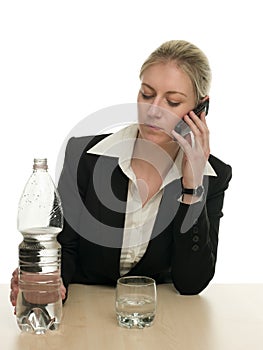 Businesswoman on a phone ready to pour water