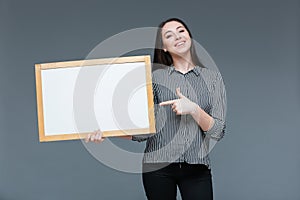 Businesswoman pointing finger on blank board