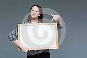 Businesswoman pointing finger on blank board