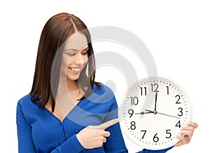 Businesswoman pointing her finger at wall clock