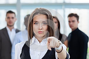 Businesswoman pointing her finger at you on the background of business people.