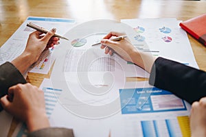 Businesswoman pointing pen on business document at meeting room. Discussion and analysis data charts and graphs showing the