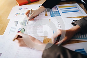 Businesswoman pointing pen on business document at meeting room.Discussion and analysis data charts and graphs showing the results