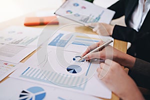 Businesswoman pointing pen on business document at meeting room.Discussion and analysis data charts and graphs showing the results