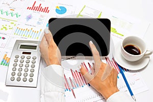 Businesswoman pointing on tablet, inside bright office.