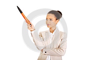 Businesswoman pointing up with big pen.