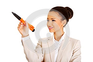 Businesswoman pointing up with big pen.