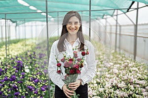 Businesswoman portrait holding a fresh flowers bouquet.