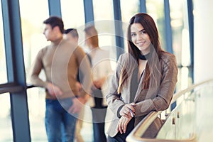 Businesswoman posing while others business people talking