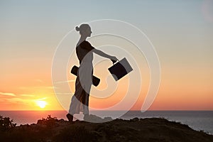 Businesswoman posing on sea sunset landscape. Remote work and business travelling idea. Life and work balance idea