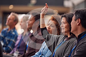 Businesswoman In Presentation At Conference Raising Hand To Ask Question