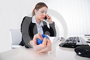 Businesswoman Pressing Stressball At Desk