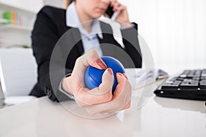 Businesswoman Pressing Stressball At Desk