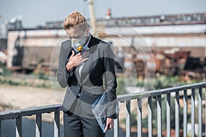 businesswoman in protective mask touching chest on bridge air