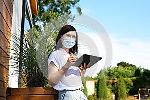 A businesswoman in a protective mask works online.