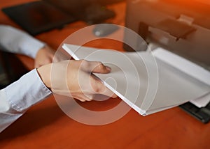 Businesswoman pull pieces of paper from the printer