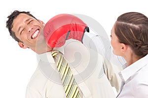 Businesswoman punching businessman with boxing gloves