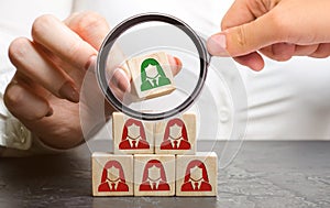 Businesswoman puts wooden blocks with the image of female employees. The concept of management in a team. Human resources. Women`