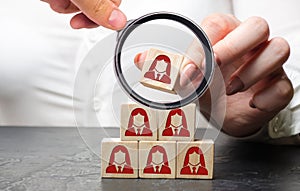 Businesswoman puts wooden blocks with the image of female employees. The concept of management in a team. Human resources. Women`