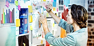 Businesswoman putting sticky notes on whiteboard