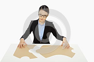 Businesswoman putting together the puzzle pieces